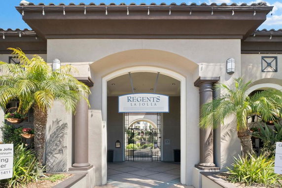 Front view of a building entrance with columns and archway.