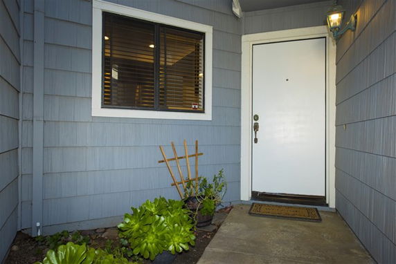 Front view of a house entrance with a white door and window next to it.