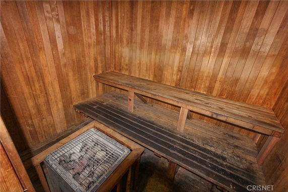 Interior view of a wooden sauna with bench seating and a heater.