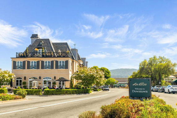 Front view of a two-story building with rooftop terrace and windows.