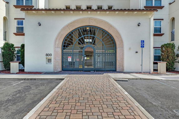 Front view of a building entrance with an arched doorway and gated entry.