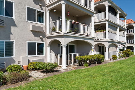 Front view of a multi-level building with balconies and columns.