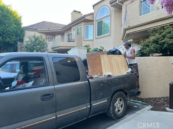 Front view of a multi-story house with a truck parked in front.