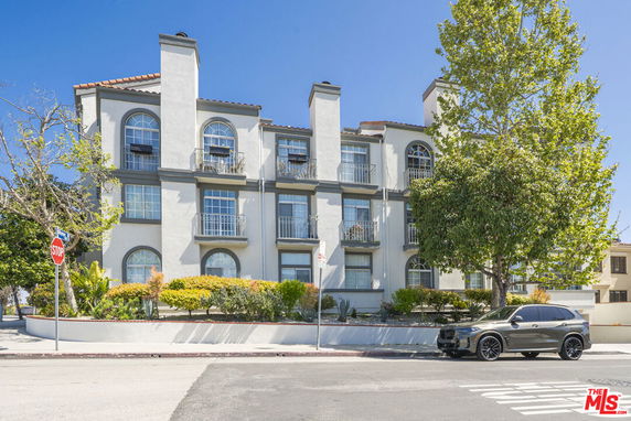 Front view of a multi-story building with arched windows and balconies.