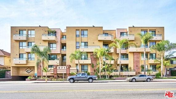 Front view of a modern multi-story apartment building with balconies.