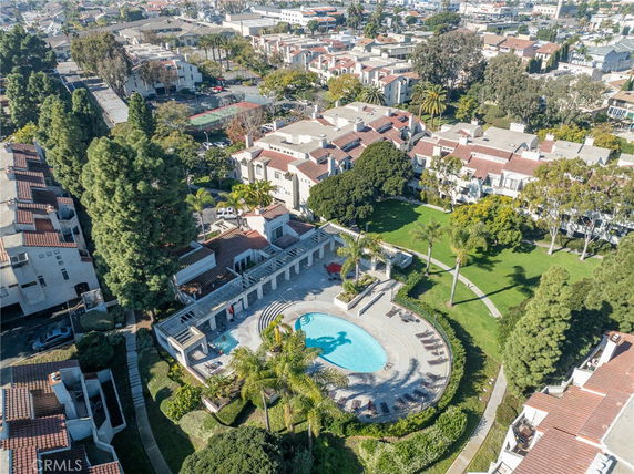 Aerial view of residential buildings with a central swimming pool and landscaped courtyard.