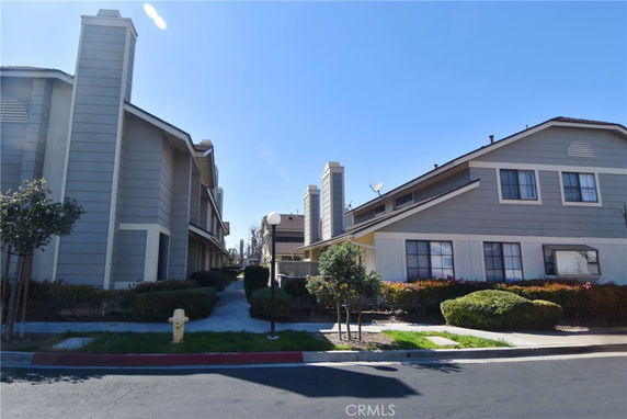 Front view of a townhouse complex with multiple stories and gray siding.