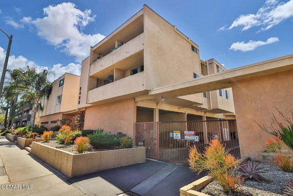 Front view of a multi-story apartment building with covered parking.