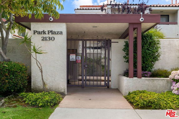 Front view of a building entrance with a gate and 'Park Plaza' signage.