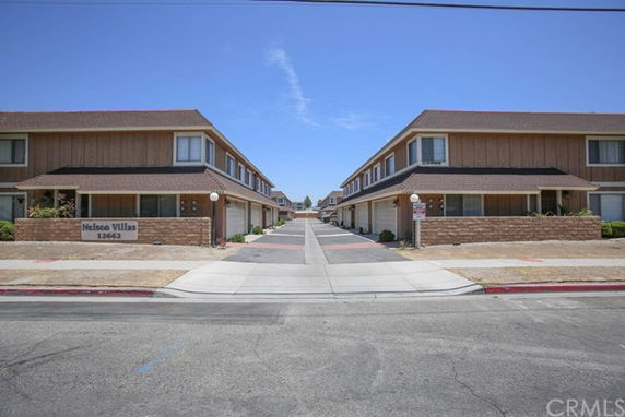 Front view of two-story apartment buildings with adjacent pathways.