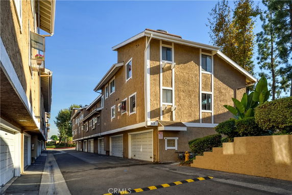 Front view of a multi-story apartment building with garages on the ground floor.