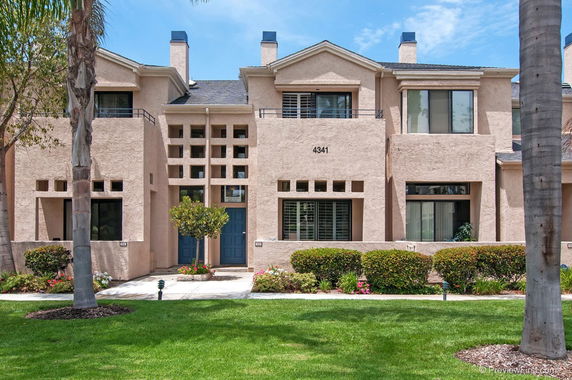 Front view of a multi-story residential building with a central entrance and multiple windows.
