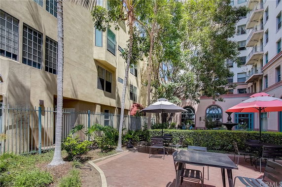 Outdoor seating area with umbrellas and tables between buildings.