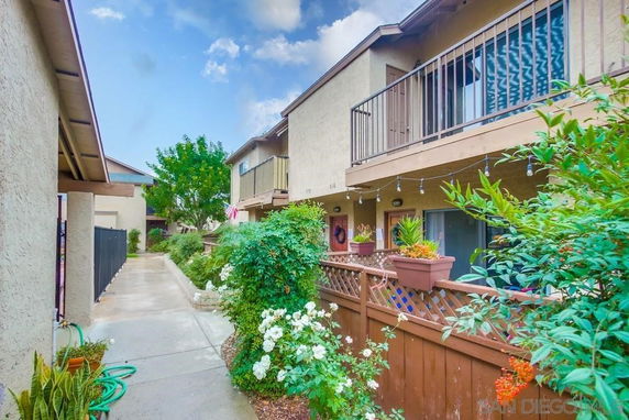 Front view of a two-story townhouse with balconies and a garden path.