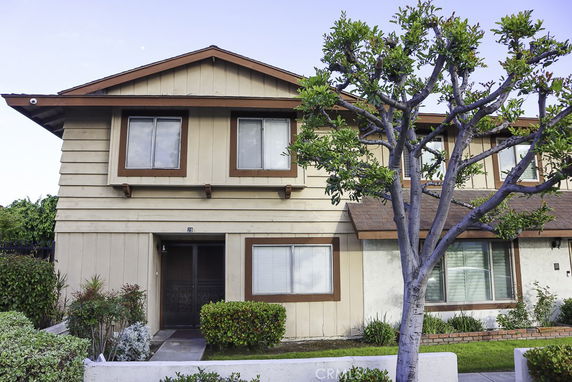 Front view of a two-story house with a brown and beige exterior.