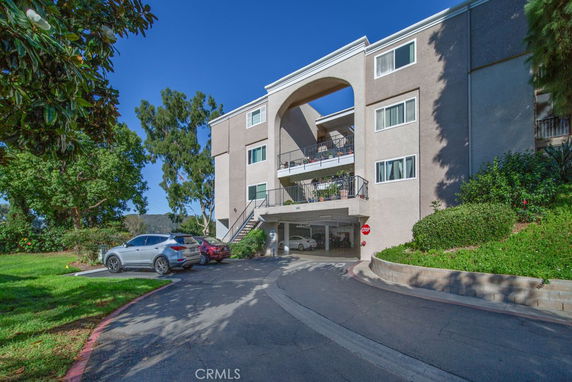 Front view of a multi-story building with an open archway on the upper level.