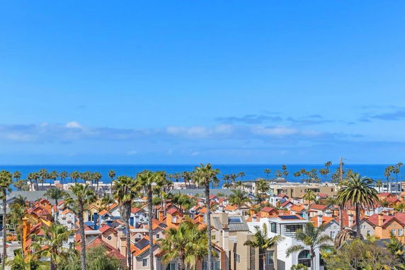 Panoramic view of a coastal area with houses and ocean in the background.