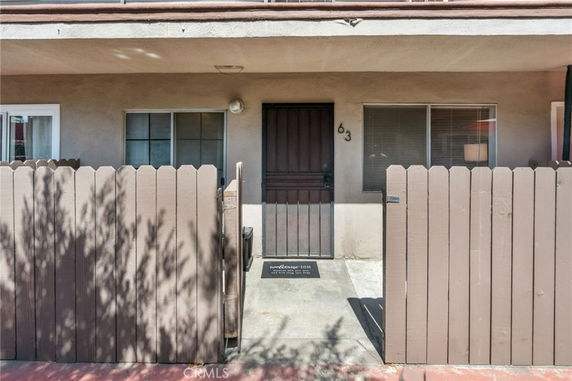 Front view of a building entrance with a gate and windows.