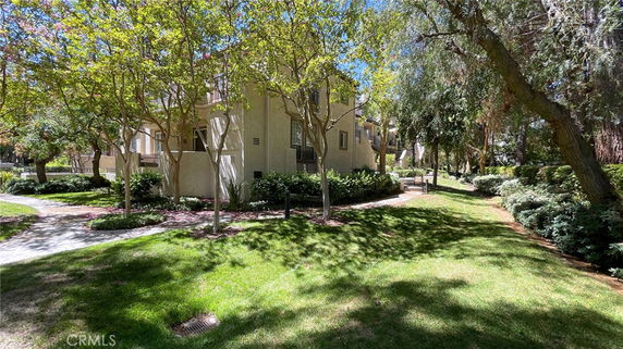 View of a multi-story residential building surrounded by trees and greenery.