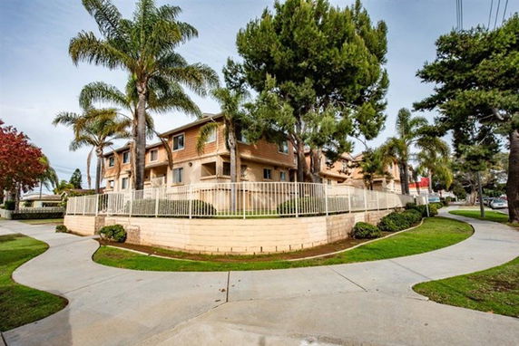 Front view of a multi-story apartment building with a gated entrance.