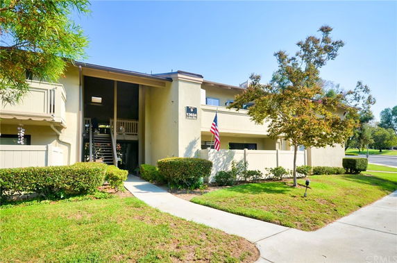 Front view of a two-story residential building with balconies and a staircase.