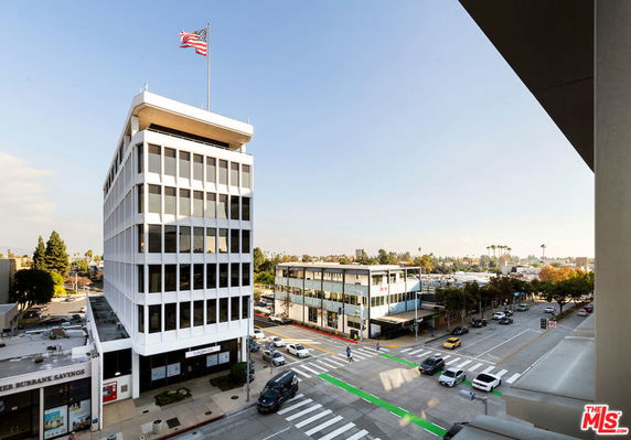 View of a cityscape with office buildings and a busy intersection.
