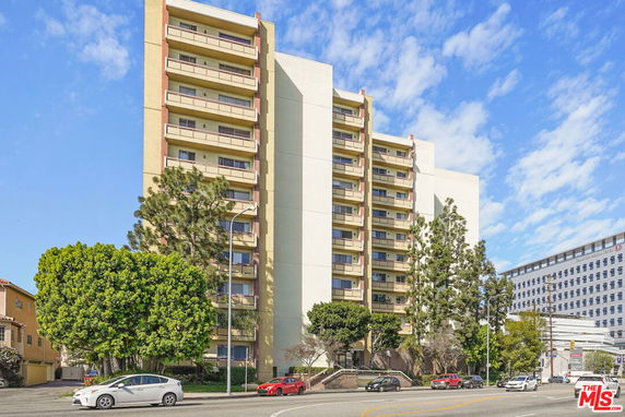 Front view of a multi-story apartment building with balconies.