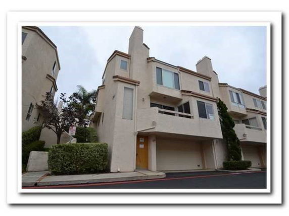 Front view of a multi-story townhouse with a garage.