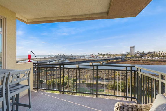 Scenic view from a balcony overlooking a river and bridge with cityscape in the background.