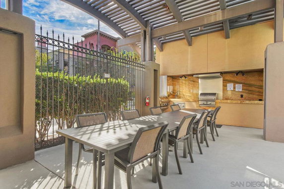 Outdoor recreation area with a long dining table and built-in barbecue facilities.