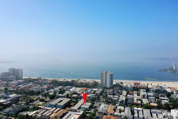 Panoramic view of a coastal cityscape with a focus on residential buildings and a body of water.