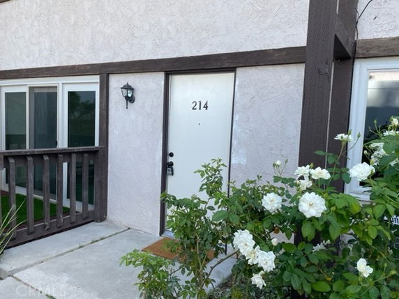 Front view of a building with a white door numbered 214 and railing.