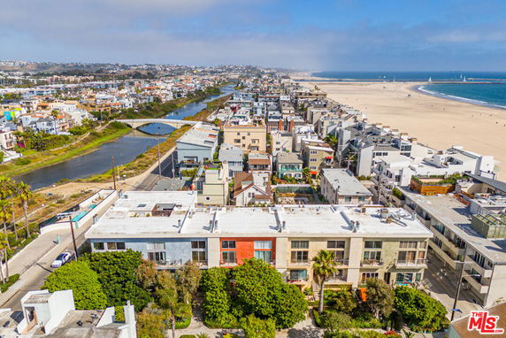 Aerial view of coastal residential area with buildings and beach.
