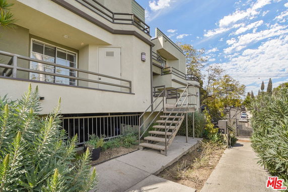 Front view of a building with an external staircase and railings.