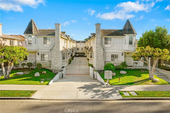 Front view of a two-story residential building with a central driveway.