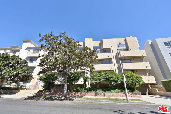Front view of a multi-story apartment building with balconies.