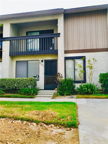 Front view of a two-story townhouse with a balcony.