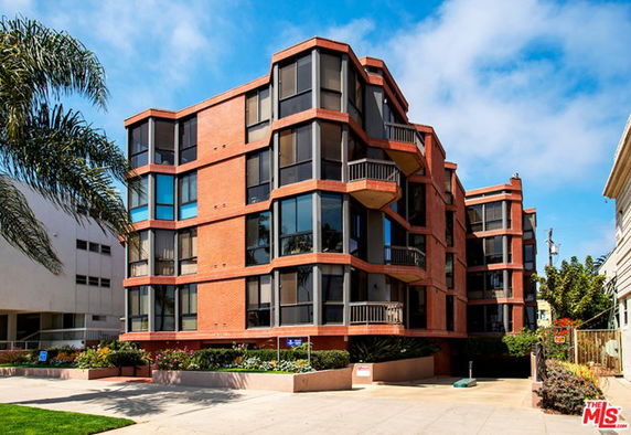 Front view of a multi-story building with large windows and balconies.
