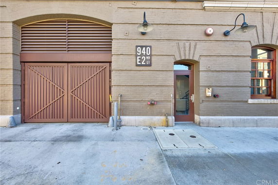 Front view of a building with an arched doorway and large wooden gate.