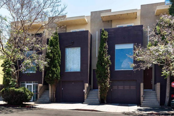 Front view of a modern townhouse with large windows and two garages.