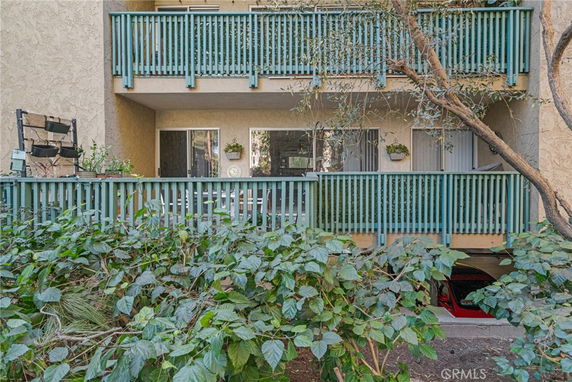 Front view of a multi-story building with balconies and wooden railings.