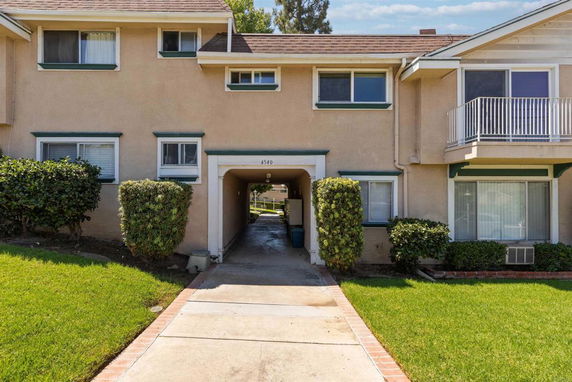 Front view of a two-story residential building with a connecting archway.