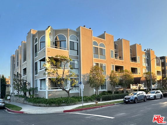 Front view of a multi-story residential building with large windows and balconies.