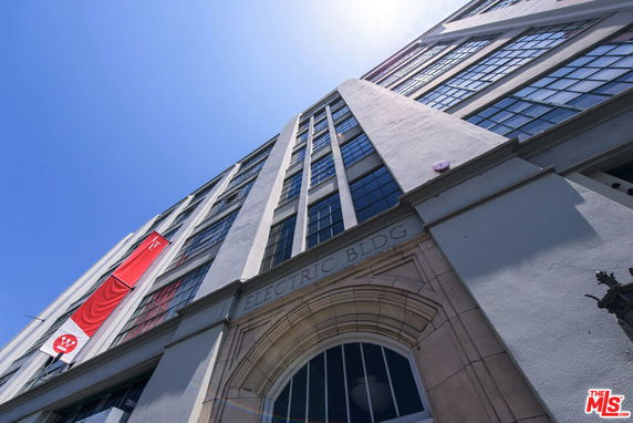Front view of a multi-story building with large windows and an arched entrance marked Electric Bldg.