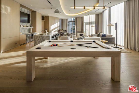 Spacious room with a pool table and modern seating area.