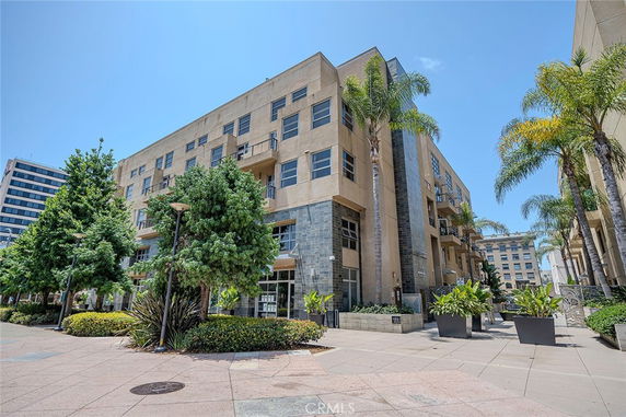 Front view of a multi-story building with balconies and large windows.