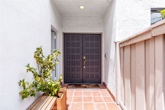 Entrance view of a house with a dark wooden front door and light-colored walls.