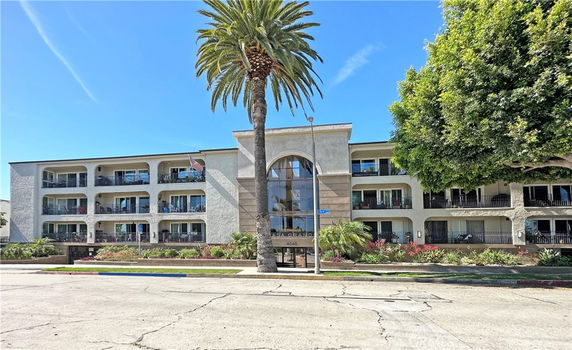Front view of a multi-story apartment building with balconies.