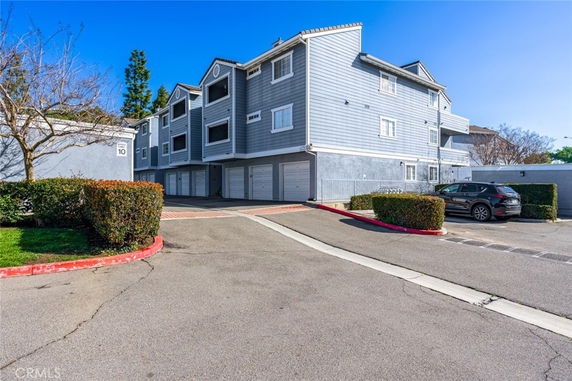 Front view of a multi-story residential building with garages on the ground level.