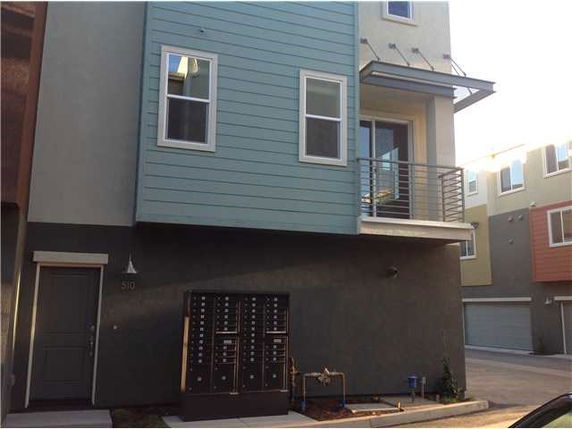 Front view of a modern multi-story building with a balcony.